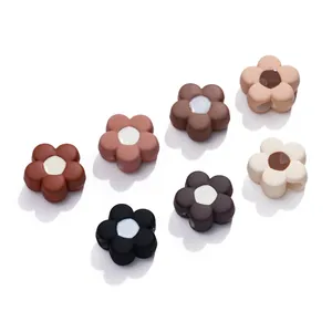 Detailed view of matte acrylic flower beads in earthy tones with holes for DIY jewelry