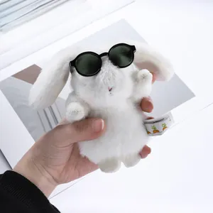 Detailed shot of white plush rabbit doll wearing black round sunglasses with chic label