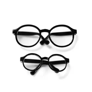 Detail of two retro round black doll glasses in large and small sizes with clear lenses