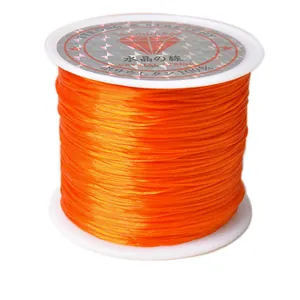 Vue détaillée du fil élastique orange robuste sur bobine pour création de bijoux DIY