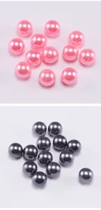 Dettaglio macro di perle in ABS rosa e grigio scuro lucido con finitura perlata lucida