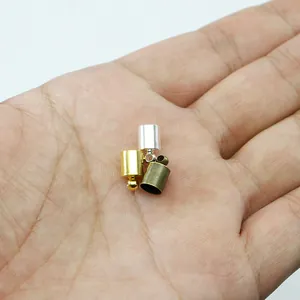 Detailed close-up of small metal tassel end caps in gold, silver, and bronze finishes