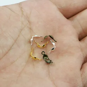 Close-up of DIY double-loop metal crimp beads in silver, gold, and bronze finishes