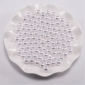 Close-up van witte ronde parels met centrale gaten in een decoratieve keramische schaal