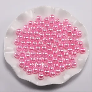 Macro-opname van glanzende roze ABS-parels in een decoratieve schaal voor DIY-sieraden