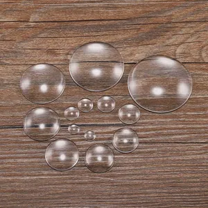 Vista macro di cabochon in vetro rotondi trasparenti di varie dimensioni su legno scuro