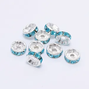 Dettaglio di perline distanziatrici argentate con cristalli strass blu chiaro