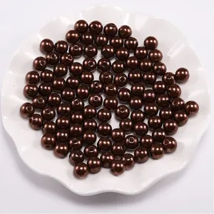 Macro shot of dark brown ABS imitation pearls with smooth finish and central drill holes