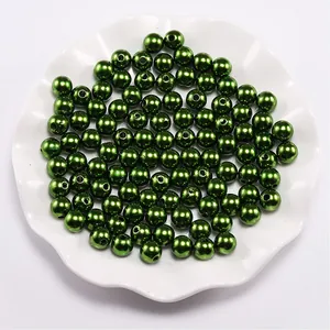 Close-up of 8mm dark green ABS faux pearls with luster finish in a white decorative bowl