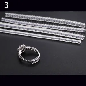 Ajusteurs de taille de bague transparents en quatre tailles avec bague en argent sur fond gris