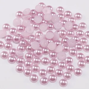 Detailed macro view of light pink half-round ABS imitation pearls with smooth glossy finish