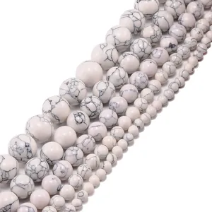 Natural white howlite stone beads in various sizes with black marble texture on white background