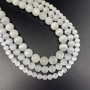 Macro shot of 8mm white cat-eye stone round beads in three sizes for DIY jewelry making