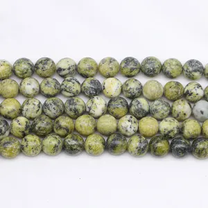Dettaglio di perline rotonde in pietra naturale giallo-verde con venature nere