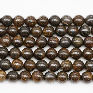 Macro shot of natural bronzite stone beads showing metallic luster and silk texture