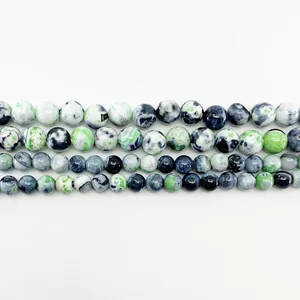 Macro detail of polished natural fire agate round beads with unique colorful marble texture