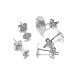 Silver metal DIY stud earring set with flat pads and butterfly backings on reflective base