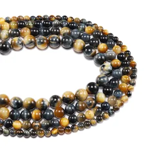 Macro shot of polished yellow and blue tiger eye beads with natural chatoyant texture