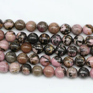 Macro detail of natural pink and black rhodonite round loose beads for DIY jewelry