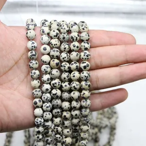 Natural 8mm Dalmatian Jasper round loose beads held by hand for DIY jewelry making