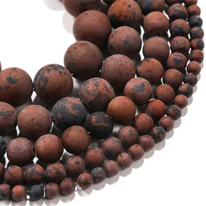 Gros plan de perles en pierre naturelle mate avec taches noires en plusieurs tailles