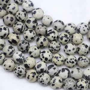 Natural Dalmatian Jasper round beads for DIY jewelry making on white fabric background