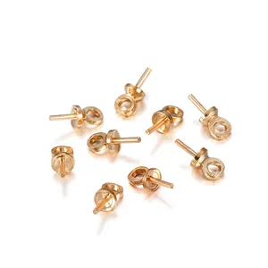 Detailed view of nine gold-plated pearl pendant caps with eye pins for DIY jewelry making