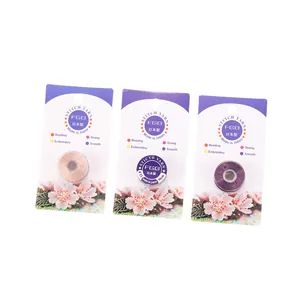 Détails de trois fils de nylon perle #11 en or, blanc et violet sur bobines de plastique