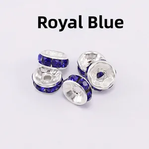 Macro shot of five silver rondelle spacer beads with royal blue rhinestones for DIY jewelry
