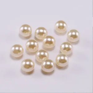 Close-up of 12 cream-colored round faux pearls with glossy finish for jewelry DIY projects