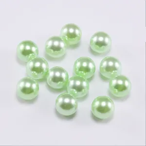 Close-up of light green solid round faux pearls with smooth glossy finish for DIY jewelry