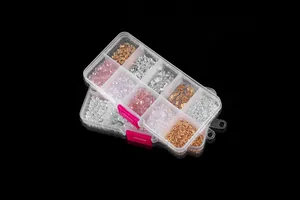 Makroansicht des DIY-Schmucksets mit Perlen, Kristallen und Metallteilen im Sortierkasten