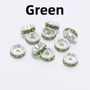 Macro shot of silver alloy rondelle spacer beads with sparkling green crystal rhinestones