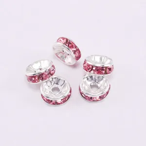 Détail macro de perles d'espacement argentées avec strass roses pour bijoux DIY
