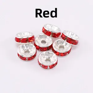 Macro detail of seven silver metal spacer beads with red rhinestones for jewelry making