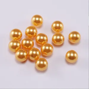 Close-up of golden ABS imitation pearls showing glossy finish for jewelry making