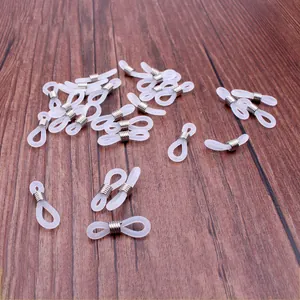Silikon-Brillenkettenschlaufen mit silbernen Metallspulen auf dunklem Holzgrund