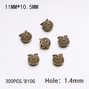 Detailed macro view of 11mm antique bronze owl spacer beads for DIY jewelry making