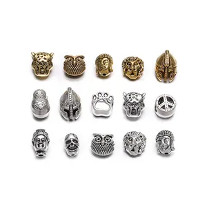 Macro shot of antique gold and silver alloy beads featuring lion and buddha head charms