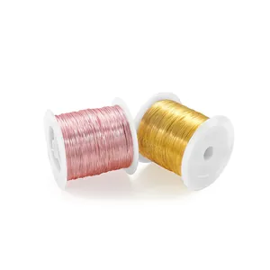Rolls of rose gold and gold craft copper wire for jewelry making on white spools