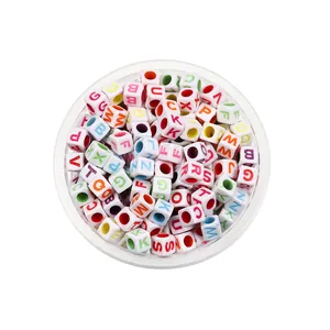 Détail de perles lettres blanches en acrylique avec lettres colorées dans un pot clair