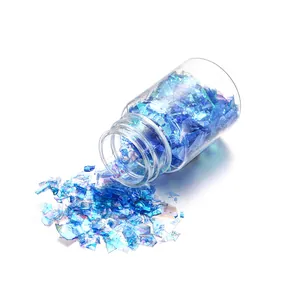 Macro detail of iridescent blue Aurora sequins in a clear 15ml glass bottle for DIY