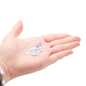 Iridescent blue DIY resin art glass bottle kit with glitter flakes held in palm