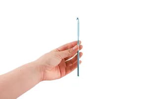 Uncinetto in alluminio azzurro tenuto in mano per lavori a maglia e progetti fai-da-te