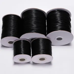 Five rolls of black waxed cord for DIY jewelry making on white spools in various sizes