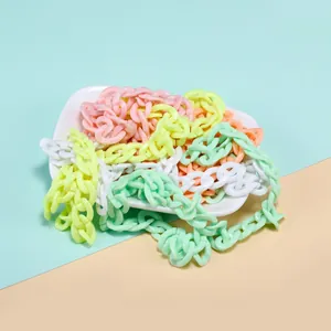 Close-up of pastel acrylic chain links in a ceramic dish for DIY jewelry making
