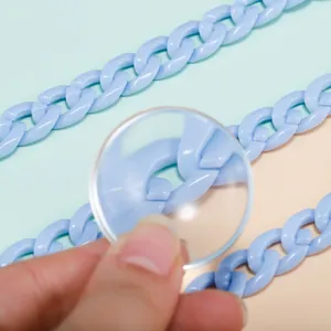 Macro view of light blue acrylic chain links showing smooth texture and DIY craft details