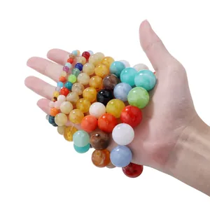 Detailed close-up of colorful round DIY beads in various sizes held in hand on white background