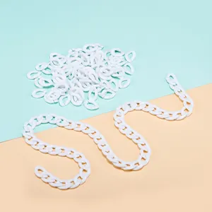 Close-up of white acrylic open jump rings and assembled chain for DIY jewelry making