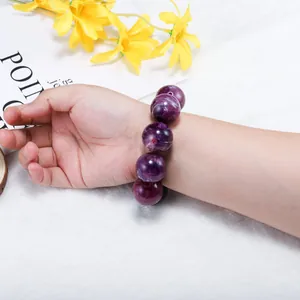 Close-up of a purple marble pattern beaded bracelet on a wrist with decorative background